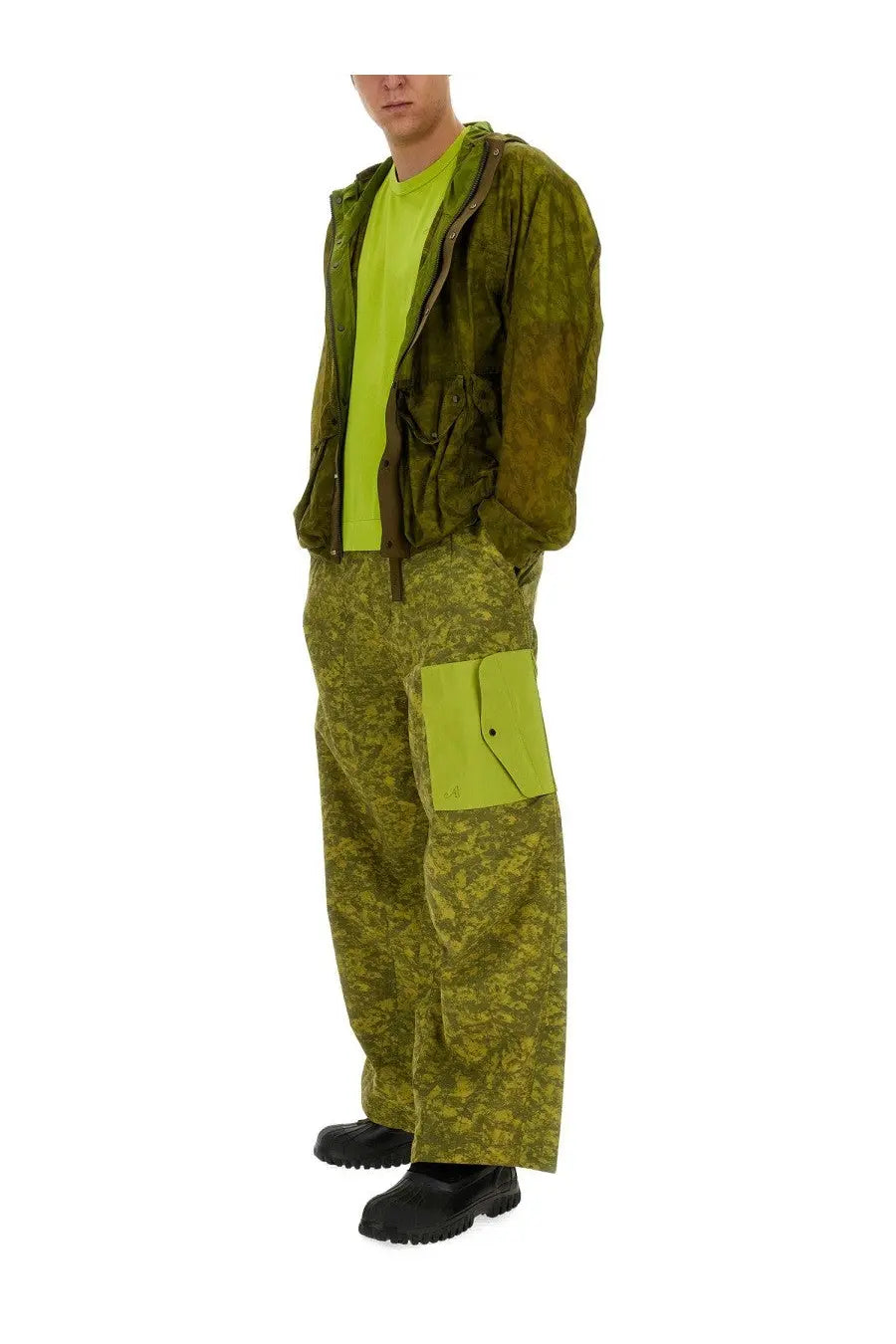 A man wearing ten c men’s cargo pants in vibrant lime green with neon green pocket accents and a matching hoodie