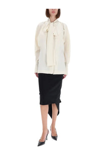 Cream-colored long sleeve blouse with a prominent bow neckline paired with thelatest women’s bree midi skirt black