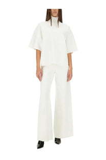 Theory women’s white turtleneck top with flared short sleeves styled with wide-leg trousers in a minimalist look