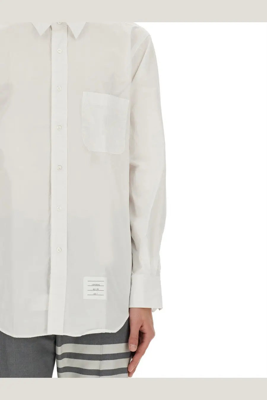 Thom Browne men’s white button down shirt with subtle texture and a small branded label at the hem