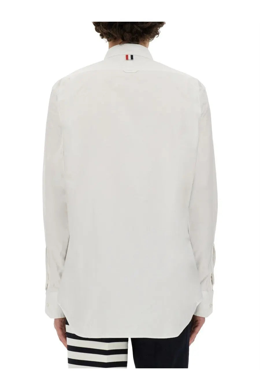 Back view of thom browne men’s white cotton dress shirt with classic collar and subtle red white blue tricolor logo