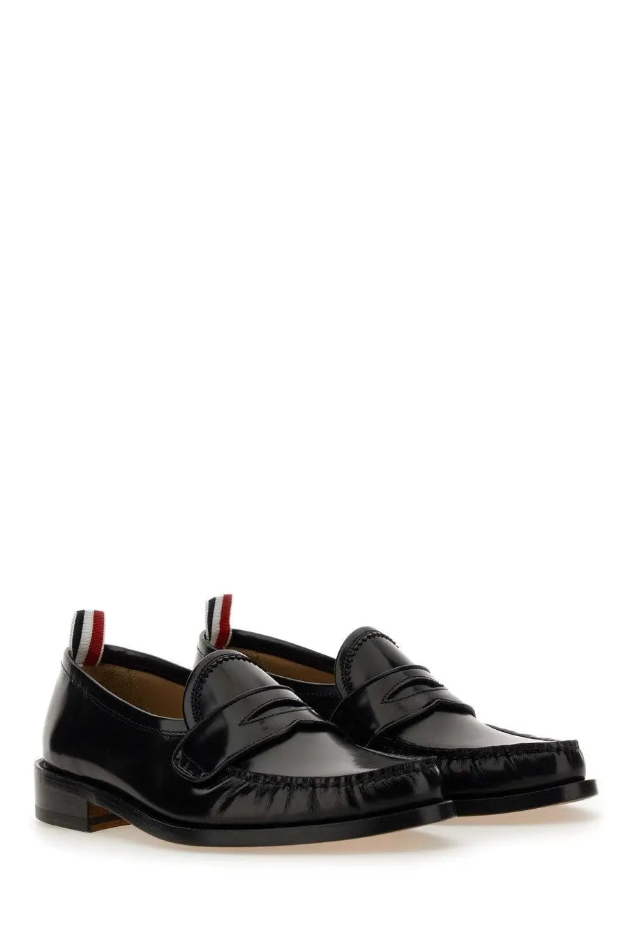 Thom Browne men’s black patent leather loafers with glossy finish and red white blue striped pull tabs visible from the back