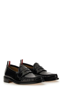 Thom Browne men’s black patent leather loafers with glossy finish and red white blue striped pull tabs visible from the back