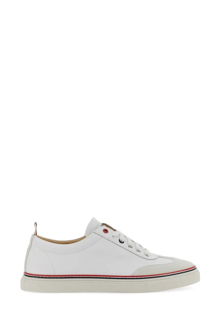 Thom Browne men’s low top leather sneaker in white with red and black striped detailing along the sole edge