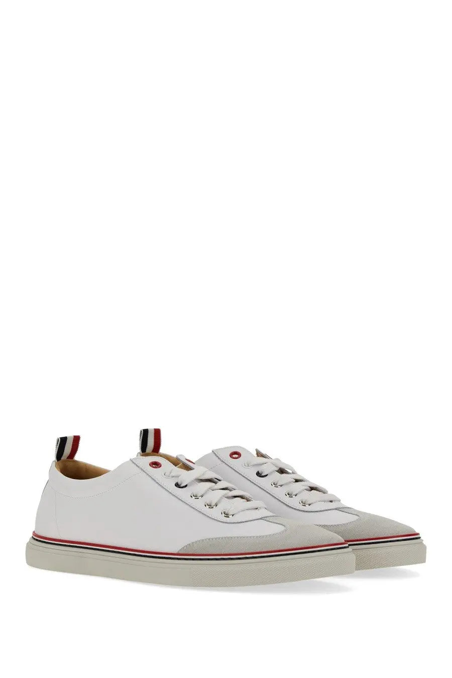 White leather thom browne men’s low top sneakers with gray toe caps red and black striped sole accents shown from back