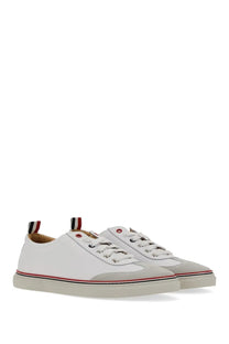 White leather thom browne men’s low top sneakers with gray toe caps red and black striped sole accents shown from back