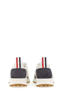Thom Browne men’s sneaker tech runner blue showing the back with white and navy suede and red white black pull tab