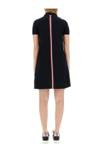 Back view of Thom Browne women’s black cotton pique polo shirt dress with vertical red white and blue stripe