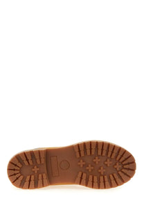 Brown rubber sole with distinctive tread pattern and timberland logo on timberland women’s waterproof yellow boots back side