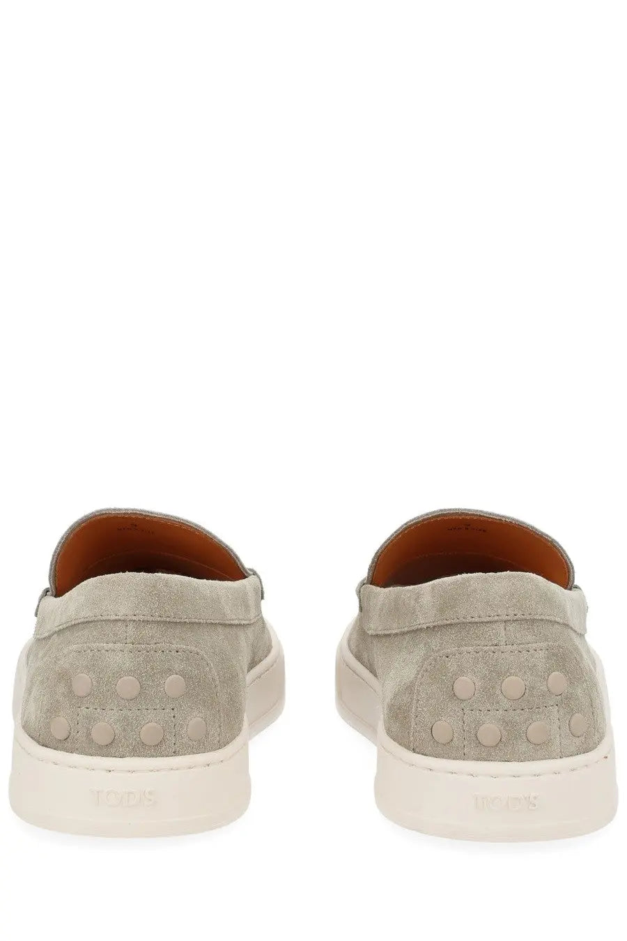 Gray suede tods men’s moccasin cassette slip-on sneakers with white rubber soles and signature circular studs on the heel back side