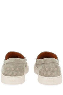 Tod’s men’s moccasin cassette beige gray suede slip-on sneakers with white rubber soles and circular studs on heel back view