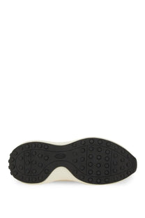 Black rubber sole with white midsole and circular tread patterns on back side of tods women’s beige fabric and suede sneaker