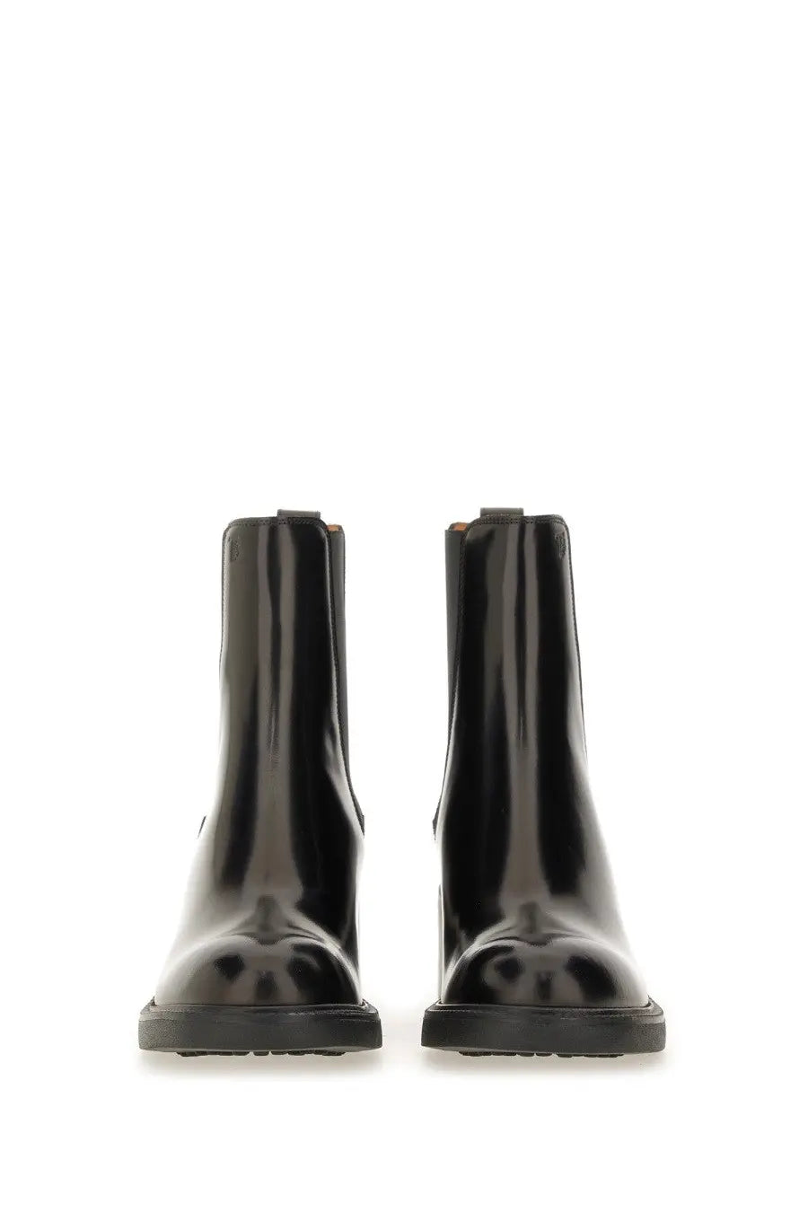 Tod’s women’s leather chelsea boots in black patent leather with a sleek glossy finish and low-profile rubber soles