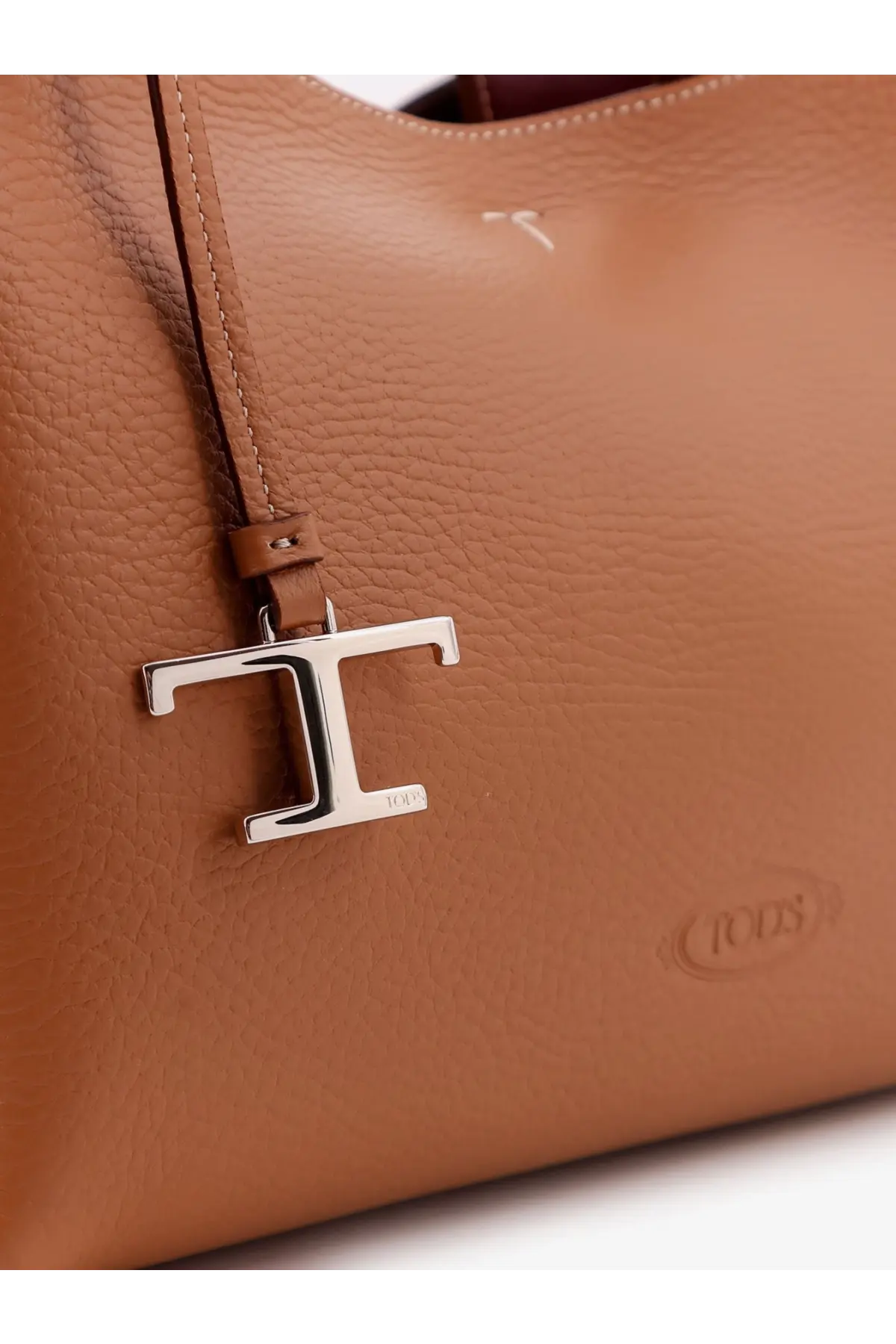 Tod’s women’s brown leather crossbody bag with tan leather tote style and silver-tone t-shaped metal charm