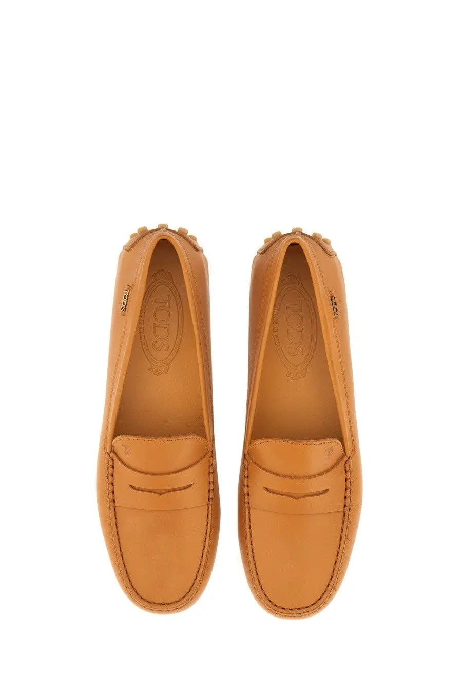 Tan leather Tods women’s gommino loafer with classic moccasin design and stitched detailing in beige
