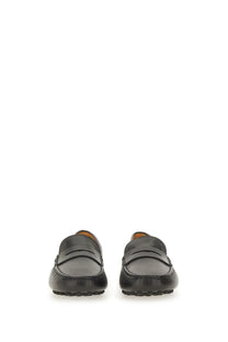 Tods women’s leather gommino loafer in black with classic penny loafer design and contrasting tan lining