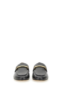 Tod’s women’s black leather loafers featuring a gold-tone bar across the top for stylish comfort