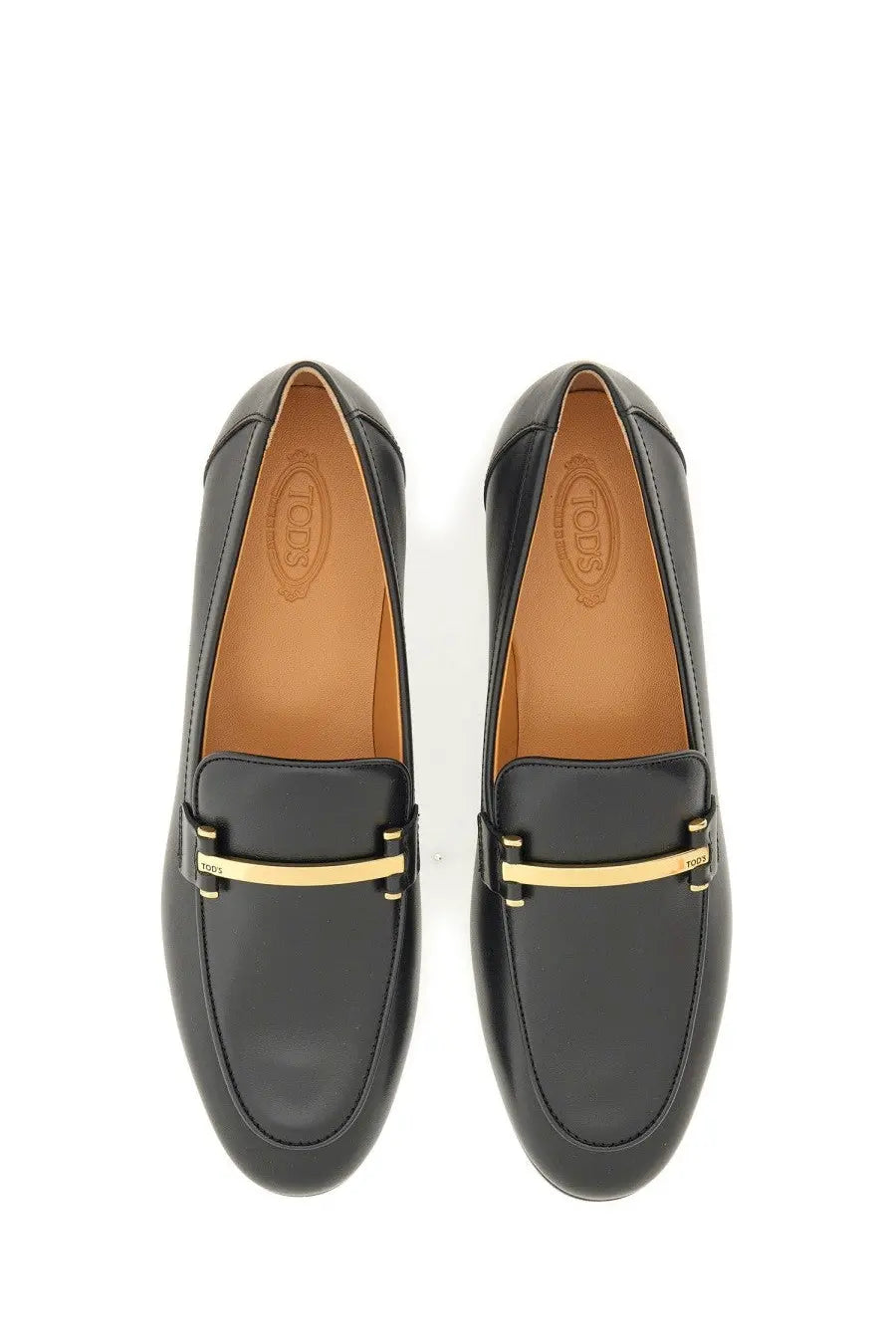 Tod’s women’s black leather loafers with a gold tone metal bar across the front for stylish comfort