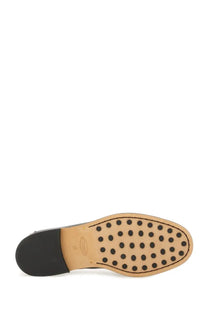 Tan leather sole with black circular studs and black rubber heel on the back of tods womens leather loafer black