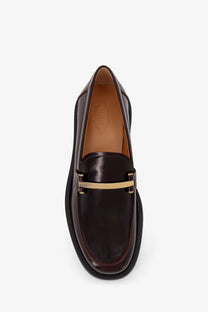 Tod’s women’s dark brown leather loafers with gold-tone metal bar across the toe in red product listing