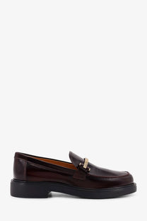 Tod’s women’s dark brown patent leather loafers with gold-tone metal buckle and thick black rubber sole