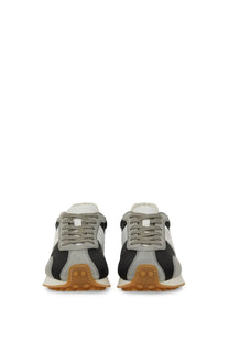 Tod’s women’s vintage sneaker grey in gray and black suede with tan rubber sole shown from the back side