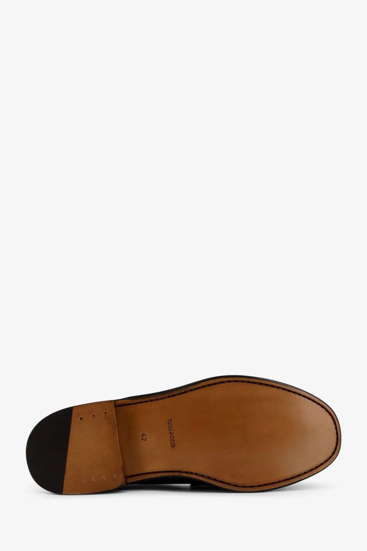 Brown leather sole of tom ford men’s leather loafer with black rubber heel and stitched edges showing brand name