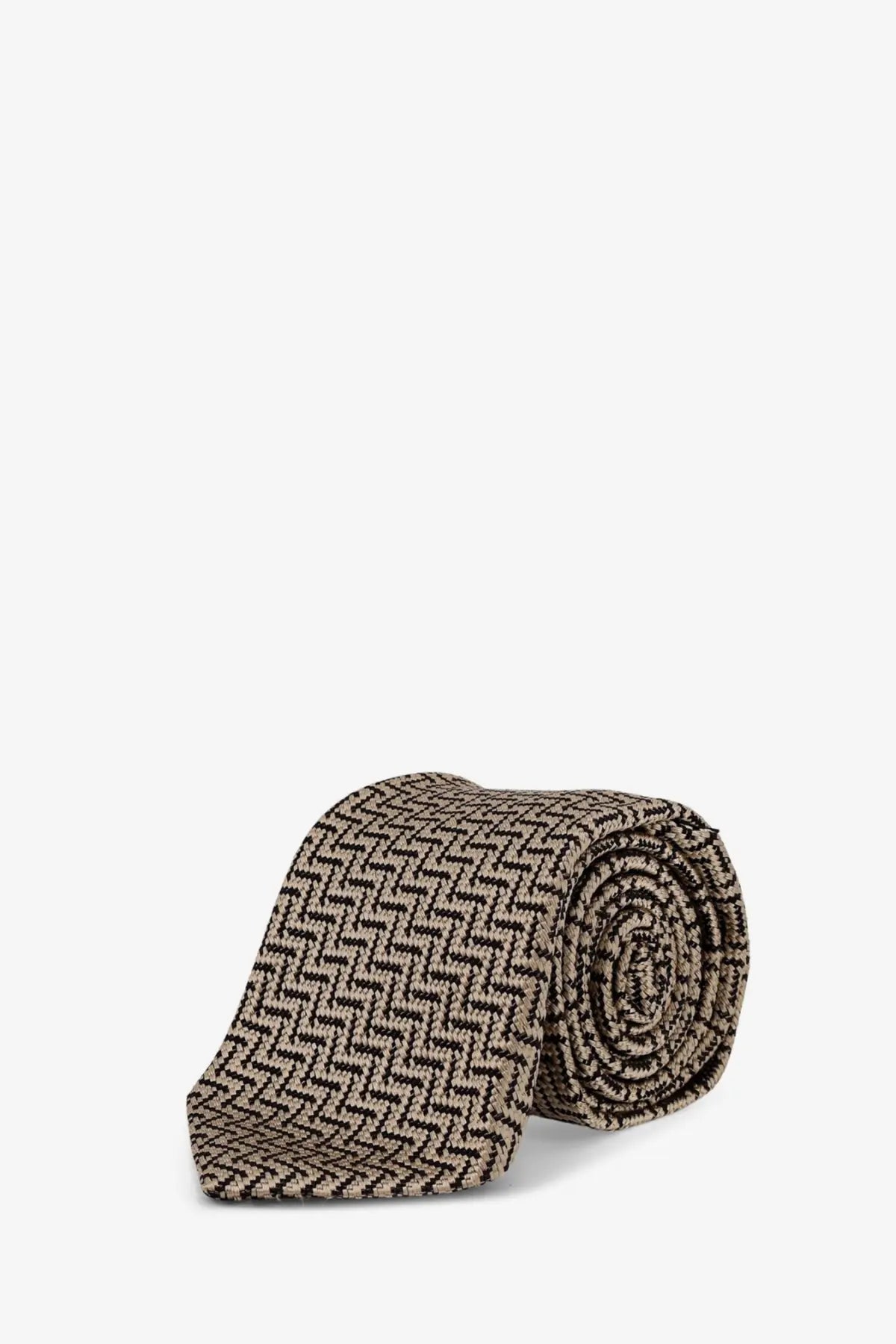 A neatly rolled tom ford men’s silk tie in beige with black herringbone pattern