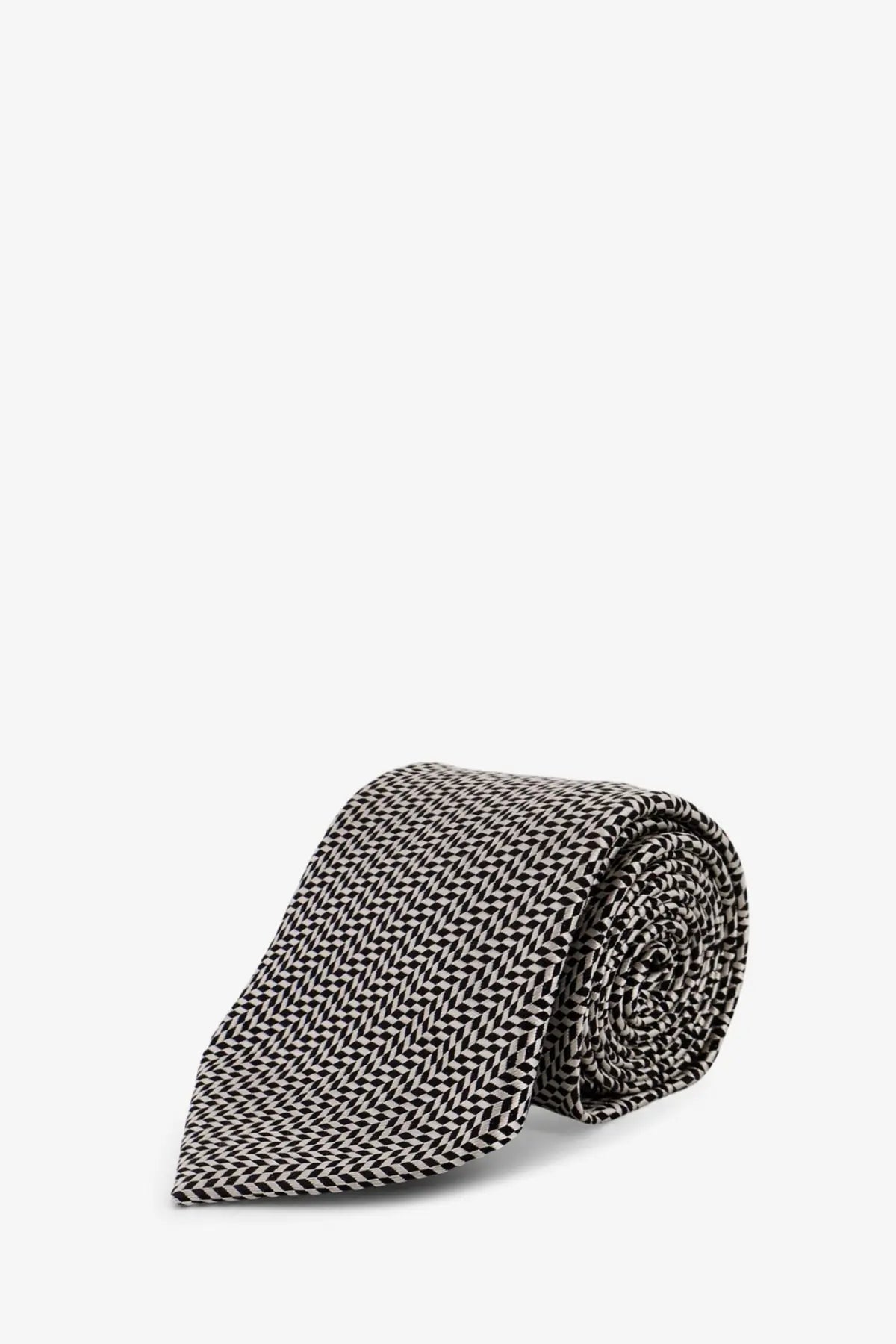 A neatly rolled tom ford men’s silk tie in black and white herringbone pattern