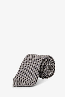 A neatly rolled tom ford men’s silk tie in grey with a subtle black geometric pattern