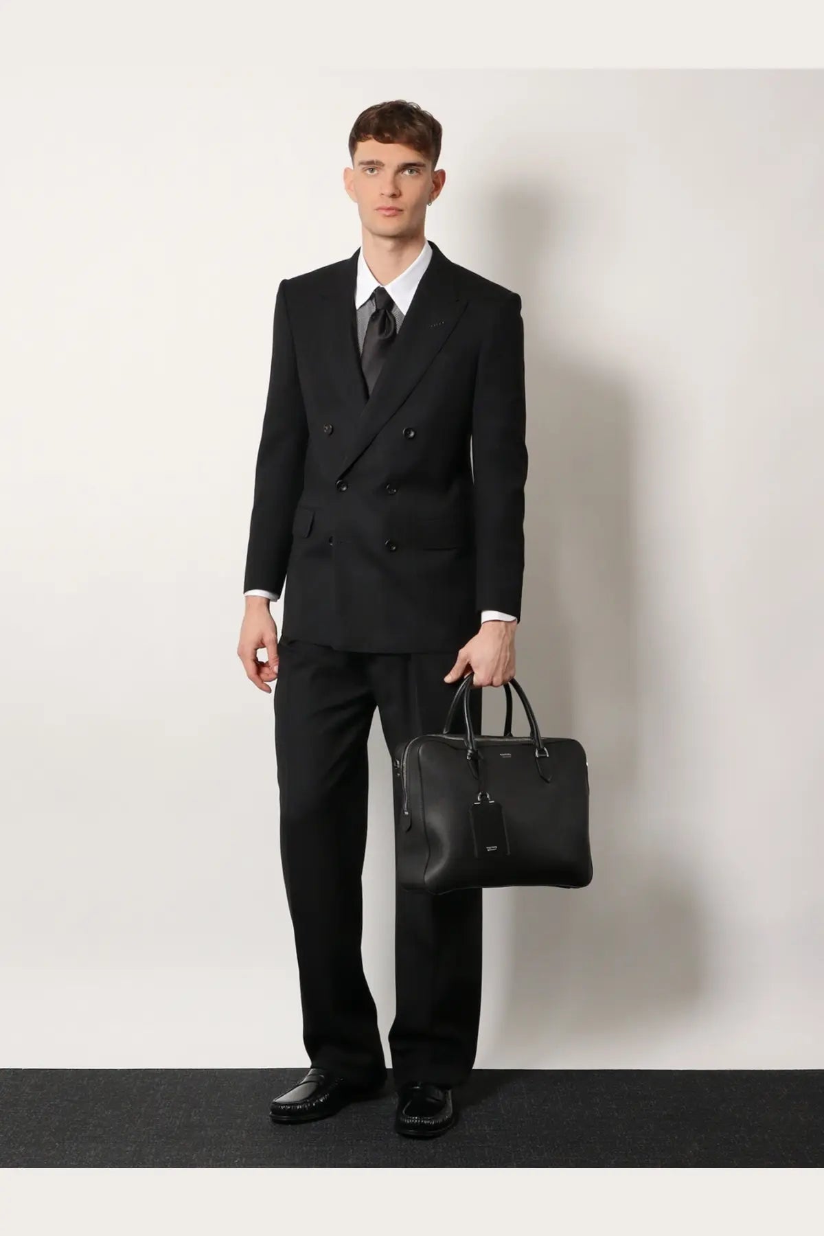 Black leather briefcase with structured design and top handles featured with Tom Ford men’s wool trousers black product