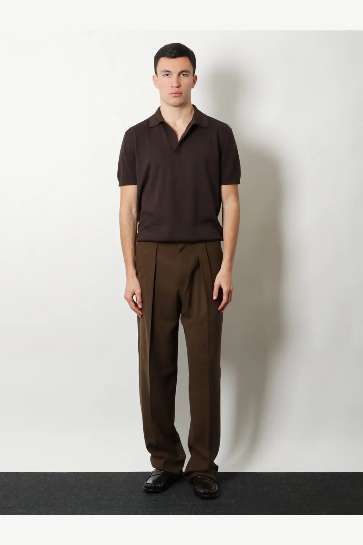 A dark brown short-sleeved polo shirt with classic collar and ribbed texture paired with tom ford brown wool trousers