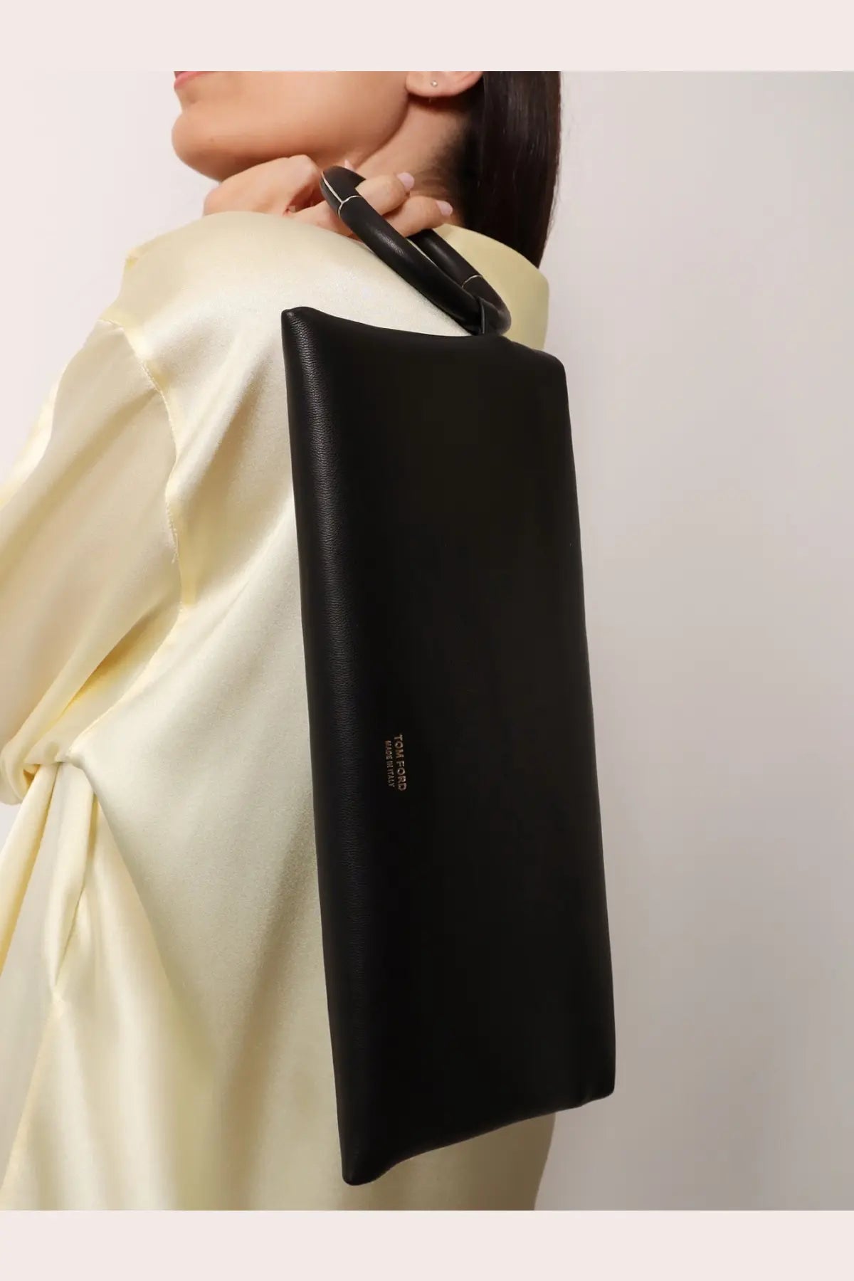 Tom Ford women’s aura black leather clutch bag with sleek minimalist design and distinctive circular handle