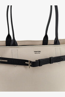 Beige Tom Ford women’s canvas tote bag with black leather handles and textured black leather belt strap with silver buckle