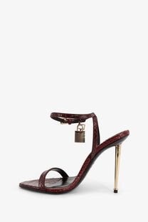 Tom Ford women’s laminated leather sandals in burgundy crocodile embossing with gold-tone stiletto heel and lock charm