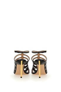 Tom Ford women’s black leather sandal with patent leather straps and a striking gold tone heel visible from the back