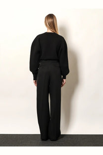 Black oversized sweater with puffed sleeves and relaxed fit paired with tom ford women’s pleated wool trousers black