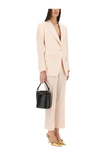 Black leather bucket bag with gold-tone bow detail and top handle paired with tom ford women’s sartorial pants wallis pink