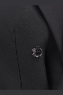 Black glossy four-hole button on tonywack men’s tailored wool blend blazer black against dark fabric background