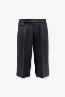 Black pleated trousers with sleek tailored fit and subtle texture paired with tonywack men’s wool blend bermuda shorts blue