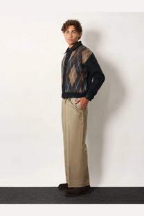 A navy blue and brown argyle patterned knit sweater with collar paired with beige tonywack unisex cotton trousers