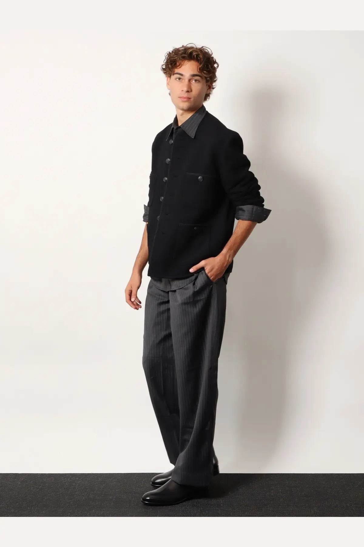 Black button-up jacket with rolled sleeves paired with dark gray pinstripe wool blend trousers from Tonywack unisex collection