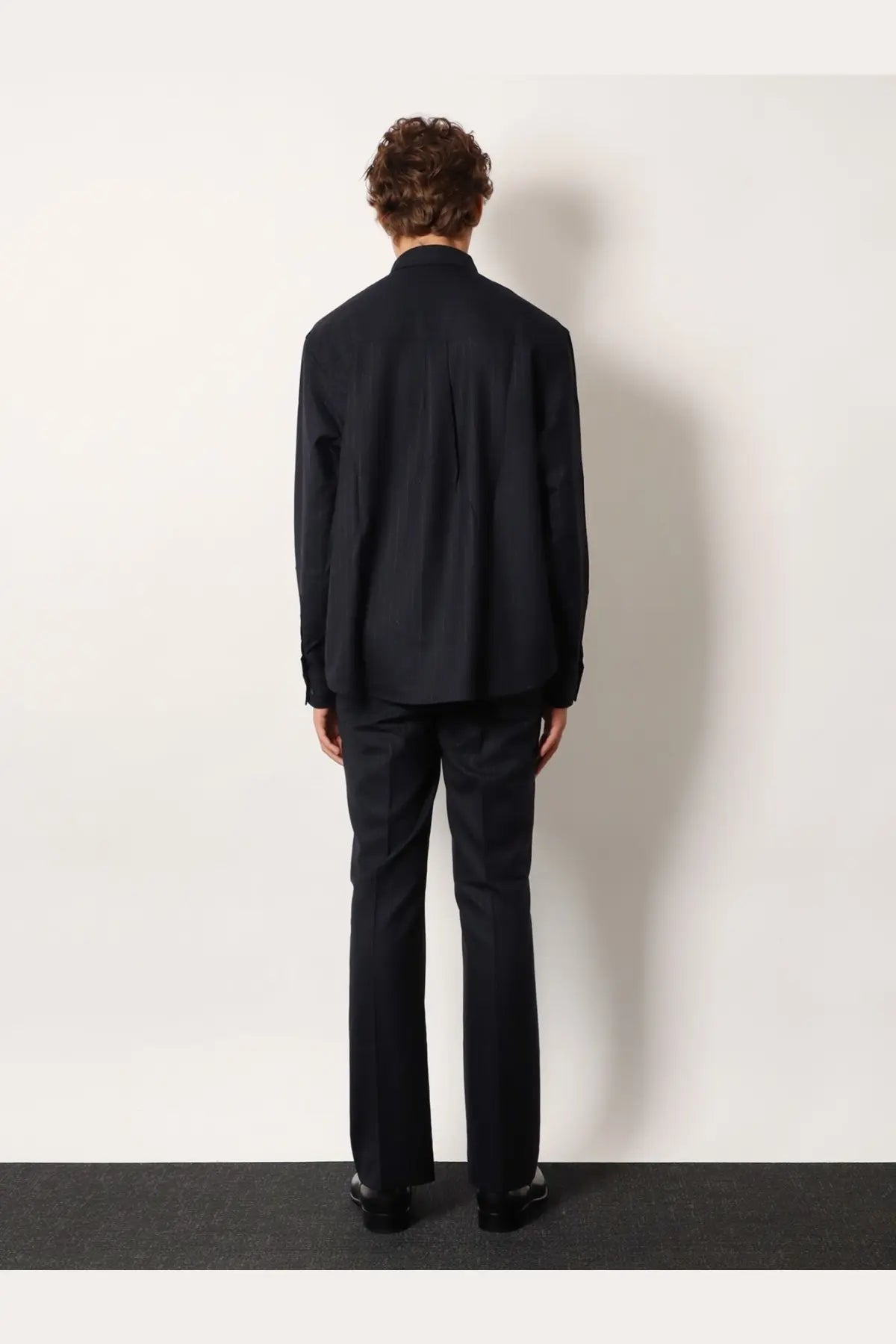 Black tailored suit with structured jacket and matching trousers in wool blend fabric for formal wear