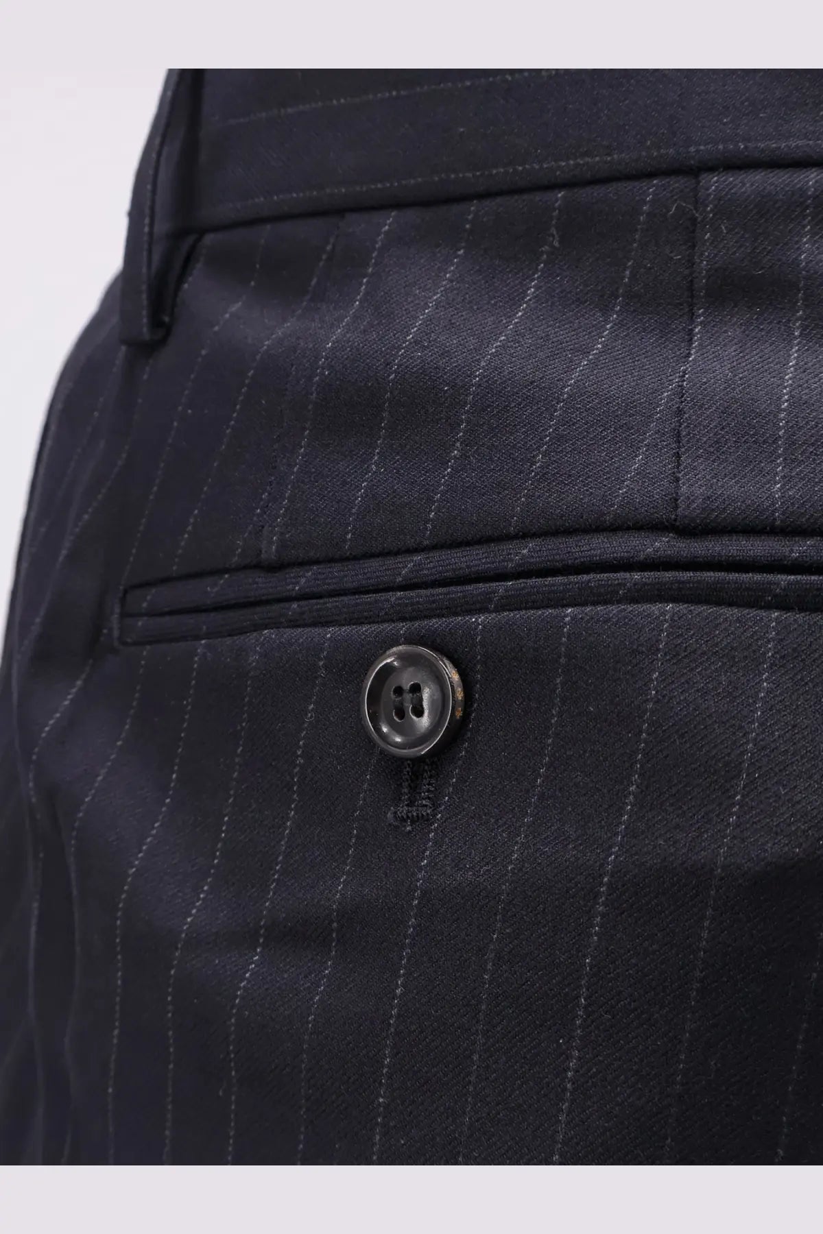 Dark navy pinstripe wool blend trousers by tonywack with subtle sheen and black button at the waistband
