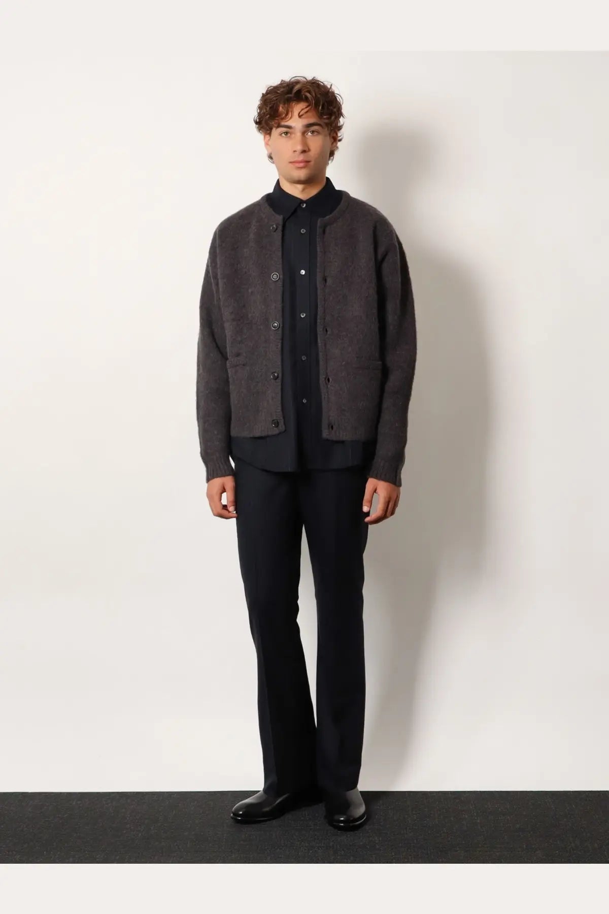 Dark gray textured knit cardigan with button closures and front pockets worn over tonywack unisex wool blend striped blue shirt