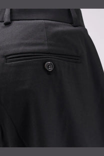 Back side of black wool blend tailored tonywack unisex trousers with subtle woven texture and single button pocket closure