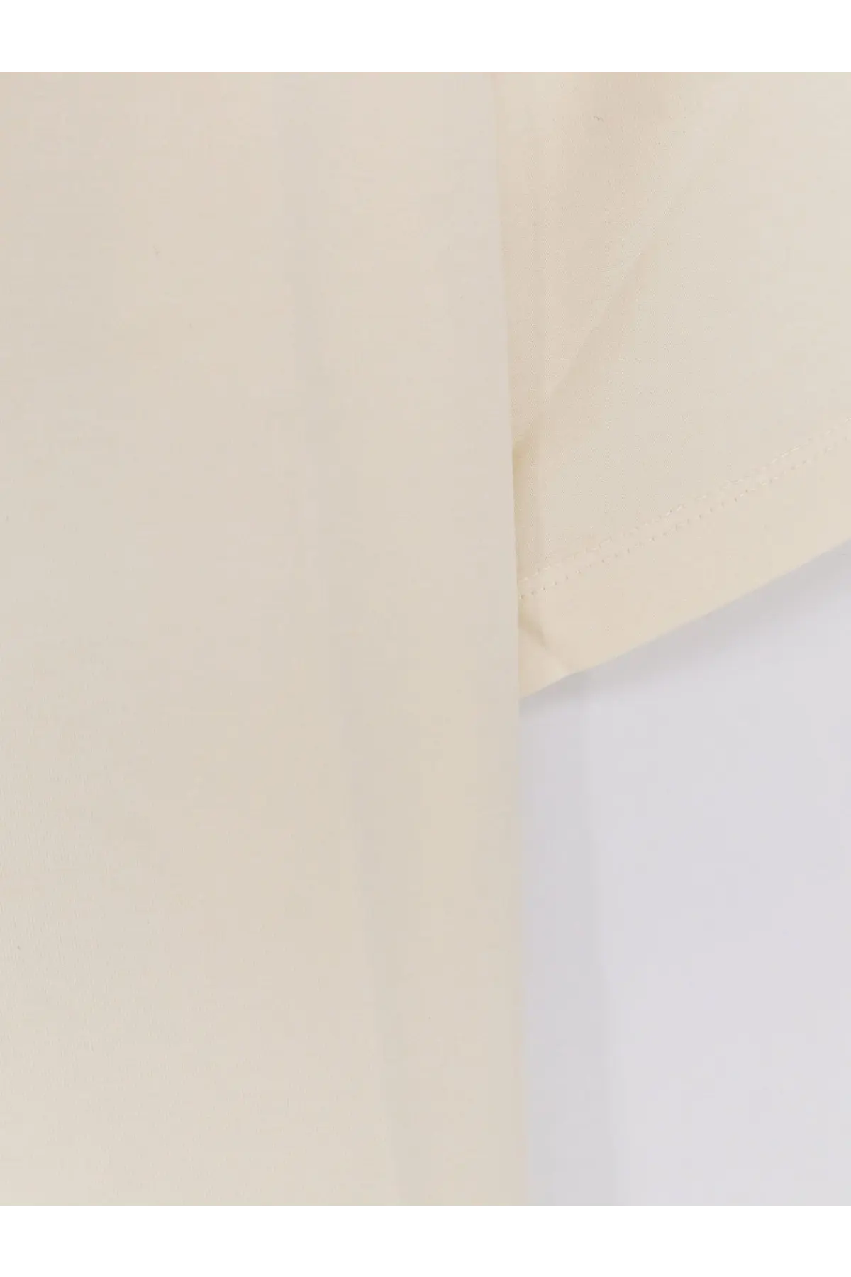 Cream-colored sleeve of tonywack women’s cotton blend shirt with soft texture and neatly stitched hem in yellow