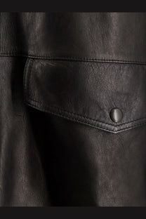 Tonywack women’s long padded black leather jacket with flap pocket secured by matching button in unisex style
