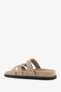 Beige suede Tory Burch women’s Ines low slide sandal with black rubber sole and adjustable strap design
