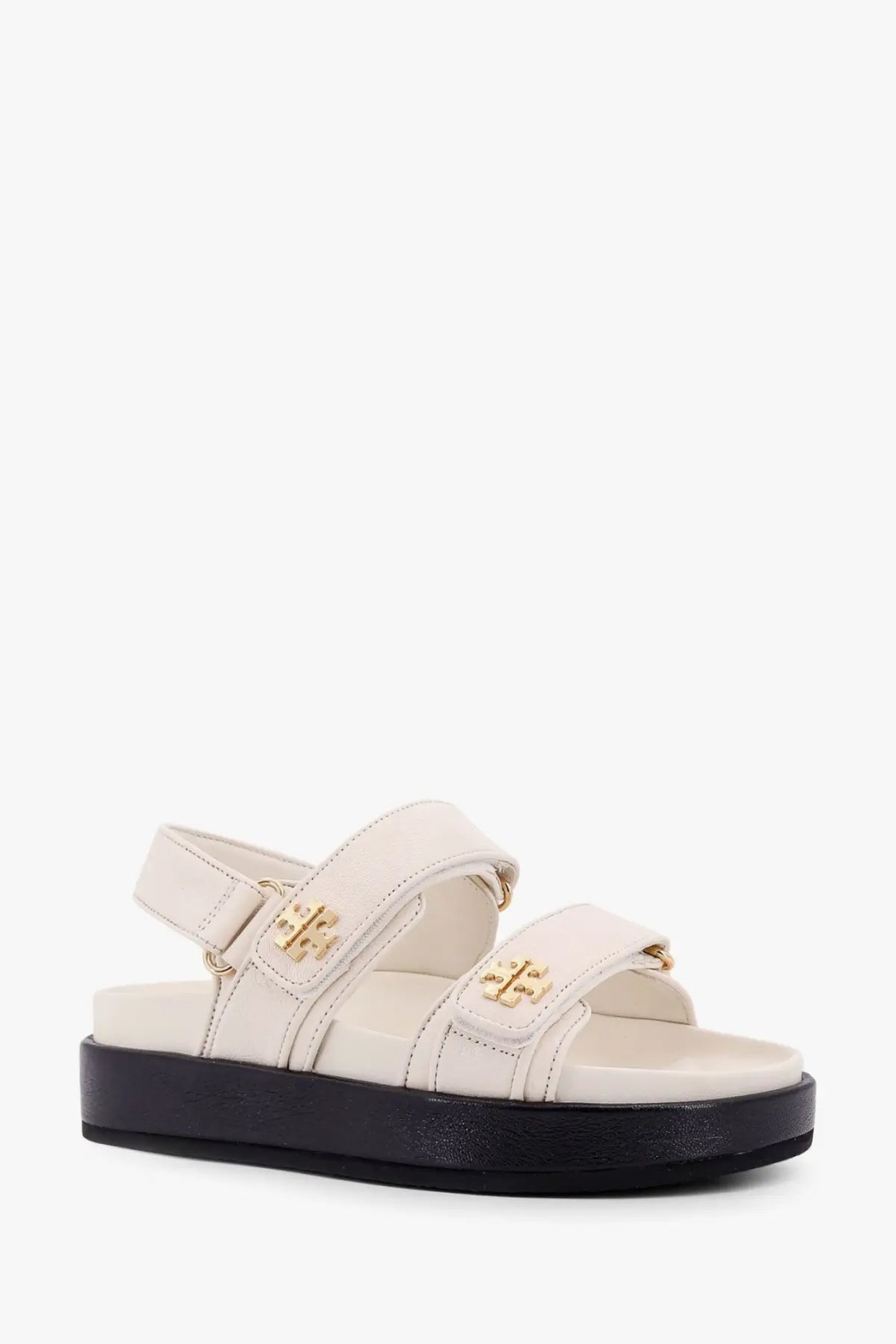 Tory Burch women’s Kira low leather sandals in cream with gold-tone logo buckles and black platform sole